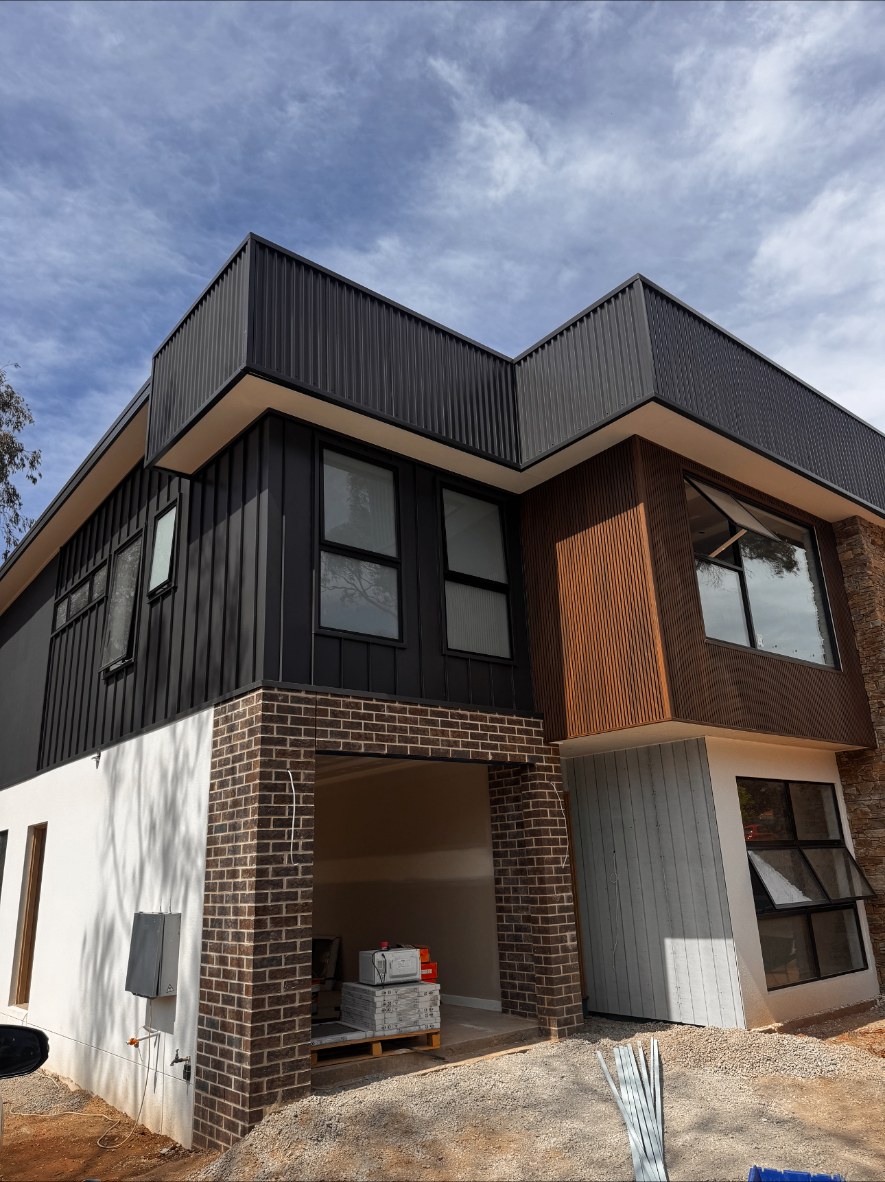 Two-storey Canberra home clad in charcoal, timber-look and profiled metal cladding